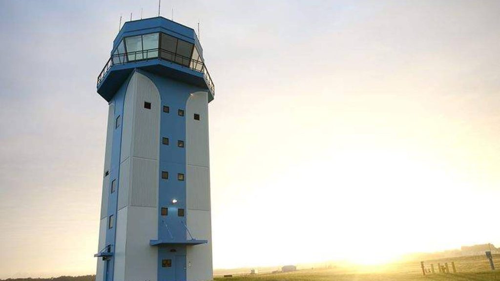 A large tower with a control tower on top of it.