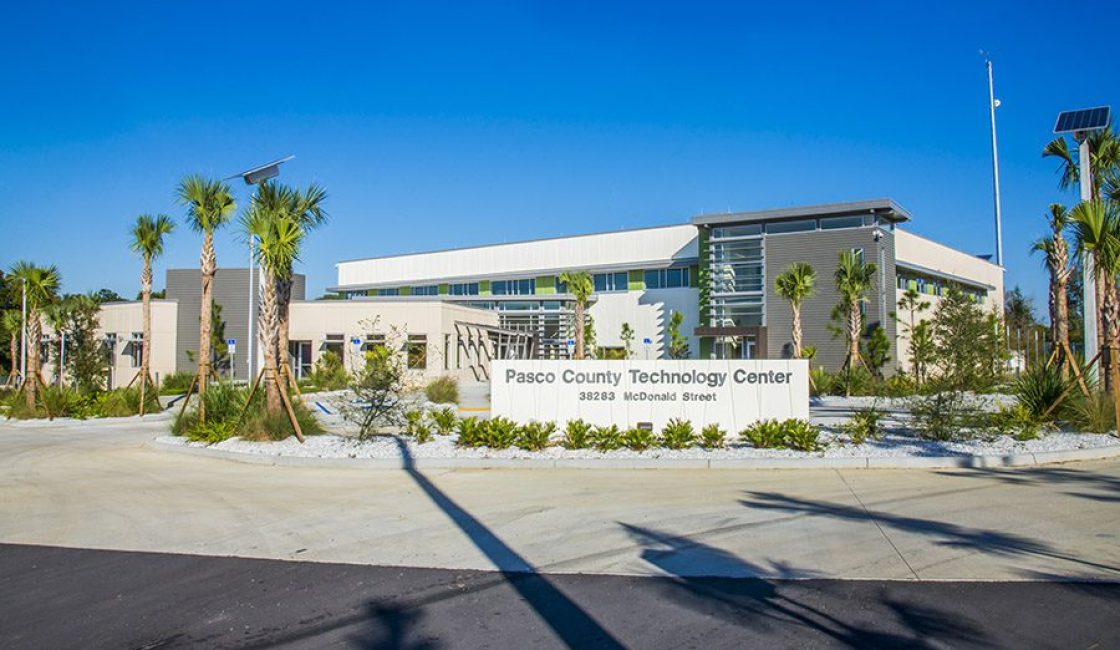 A large building with palm trees in front of it.