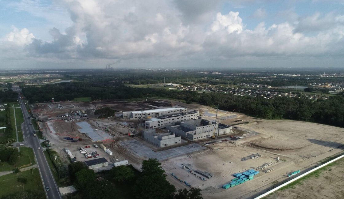 A large building under construction in the middle of a field.