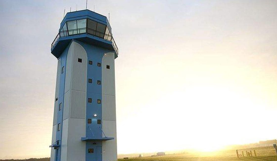 A large tower with a control tower on top of it.