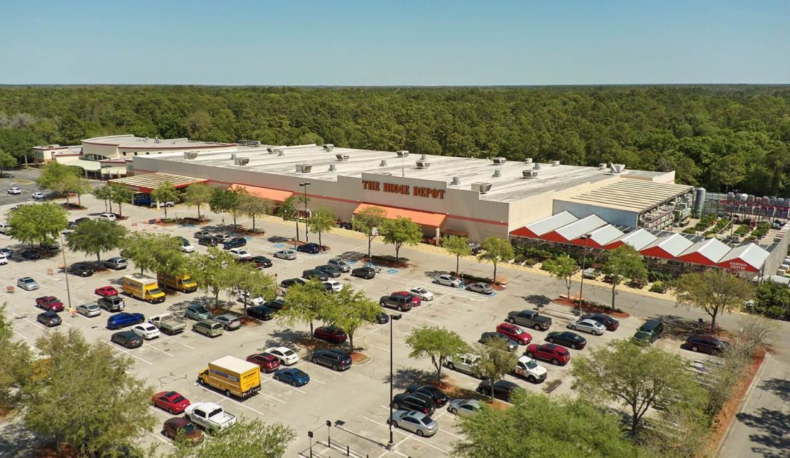 An aerial view of a parking lot with many cars parked in it.