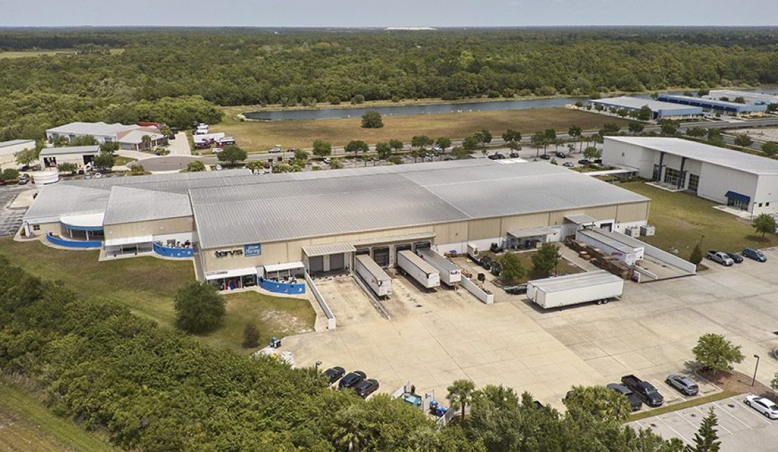 A large warehouse with many trucks parked in it.