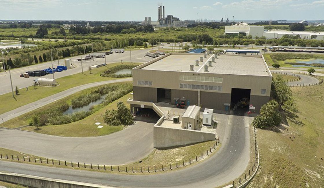 A large building with many cars parked on the side of it.