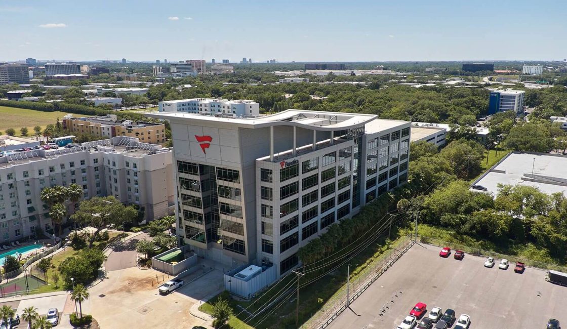 A large building with many windows and lots of parking.