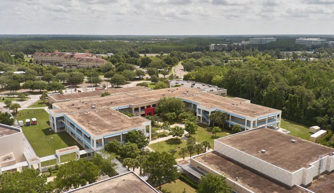 An aerial view of a building with trees in the background.