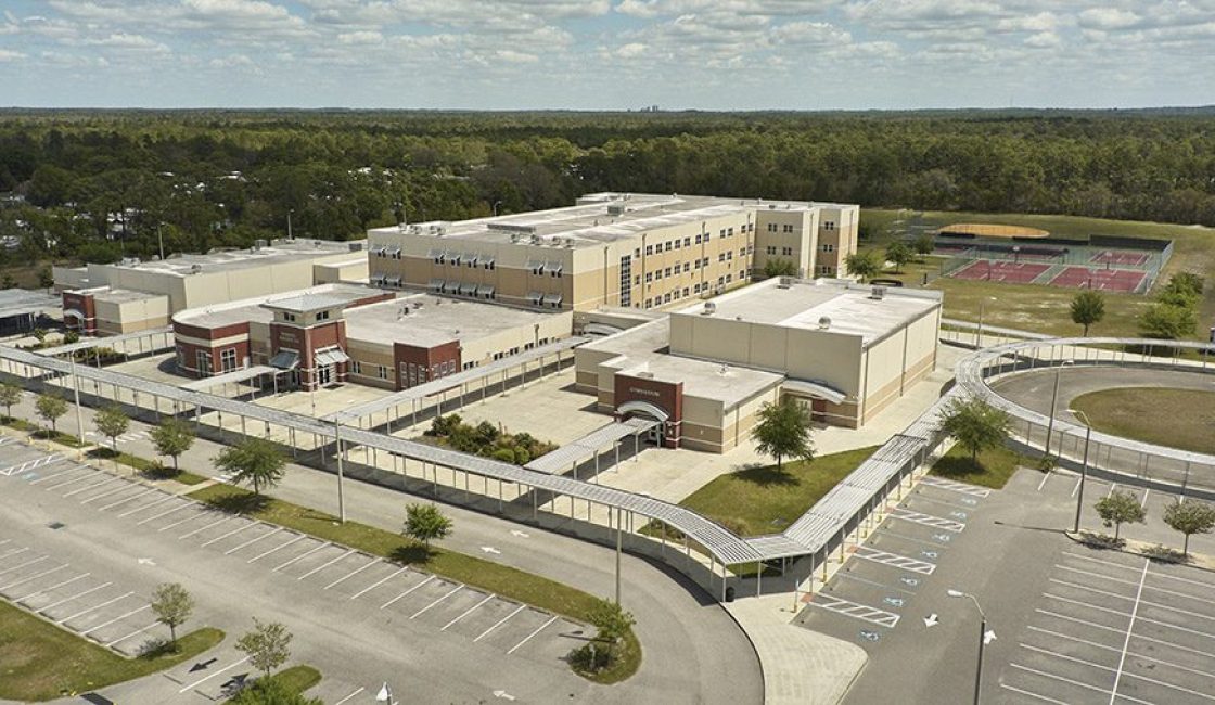 An aerial view of a large building with trees in the background.