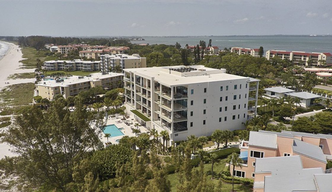 A large white building with many trees around it