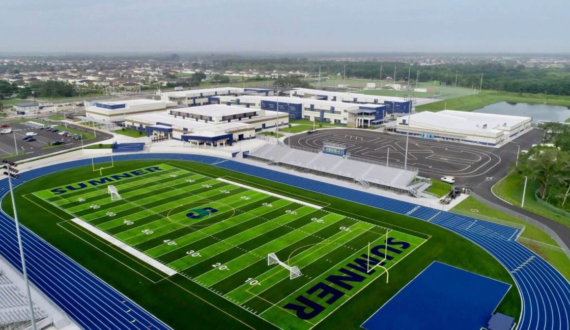 An aerial view of a football field with the stadium in the background.