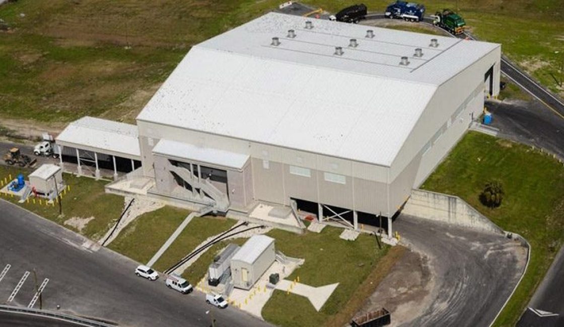 A white building with a car parked in front of it.