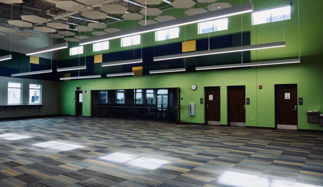 A large room with green walls and black and white tile floors.
