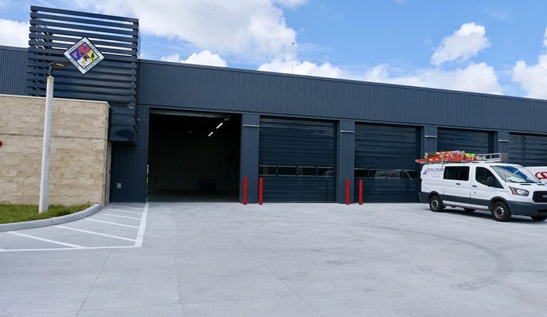 A man standing in front of a building with two doors.