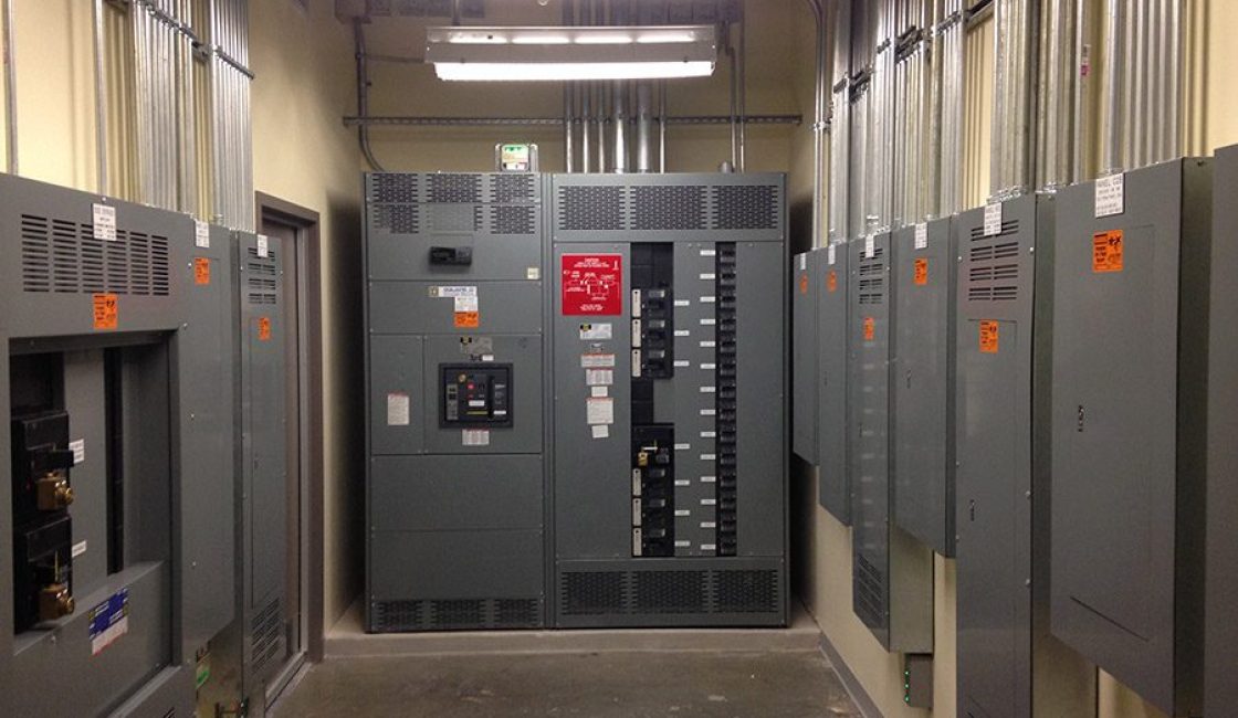 A hallway with many electrical boxes and lights.