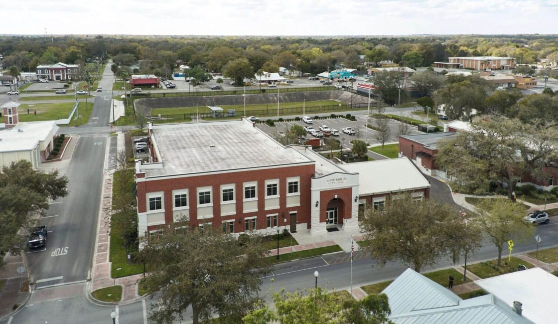An aerial view of a building with trees in the background.
