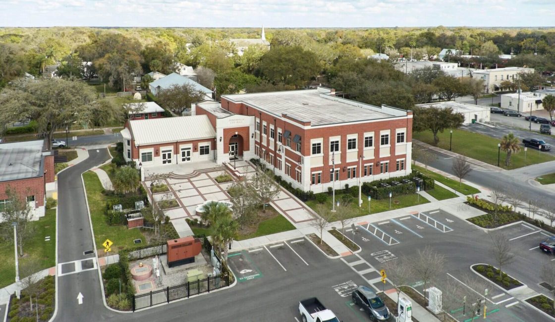 An aerial view of a building with cars parked in front.